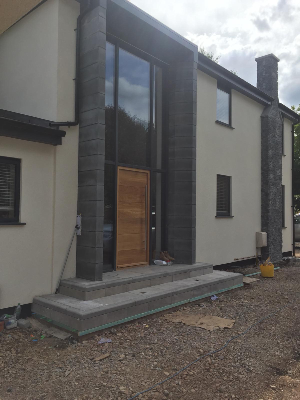 Modern dark-clad gable home with oak entrance door