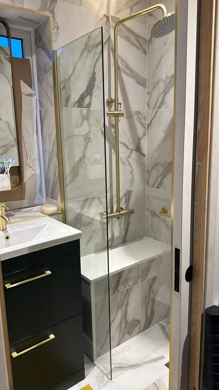 Marble en-suite with brass fixtures and herringbone wall